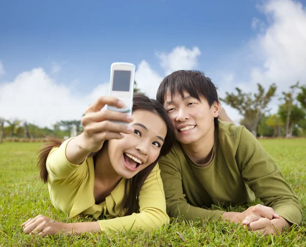 スマートな携帯電話で写真を取るアジア カップル — ストック写真