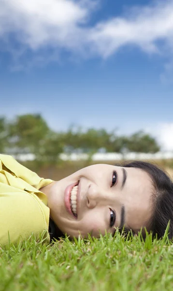Sorridente asiatica giovane donna sull'erba — Foto Stock