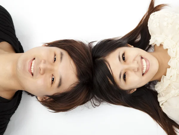 Mladý krásný pár ležící na podlaze bílé a při pohledu fotoaparát — Stock fotografie