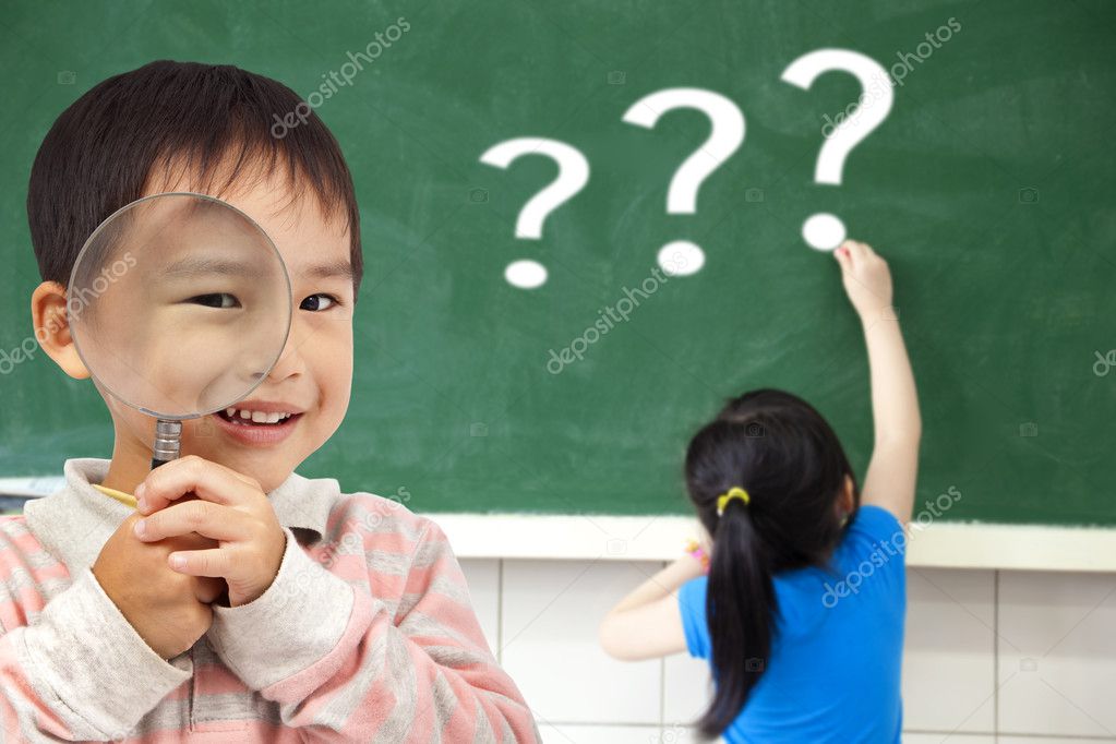 Happy kids with drawing question mark in the classroom Stock Photo by