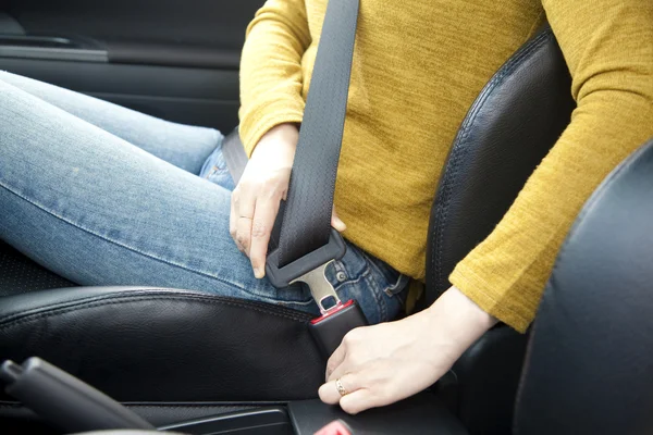 Женщина вручную пристегивает ремень безопасности в машине — стоковое фото