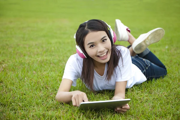 Ung kvinna med TabletPC på gräset — Stockfoto