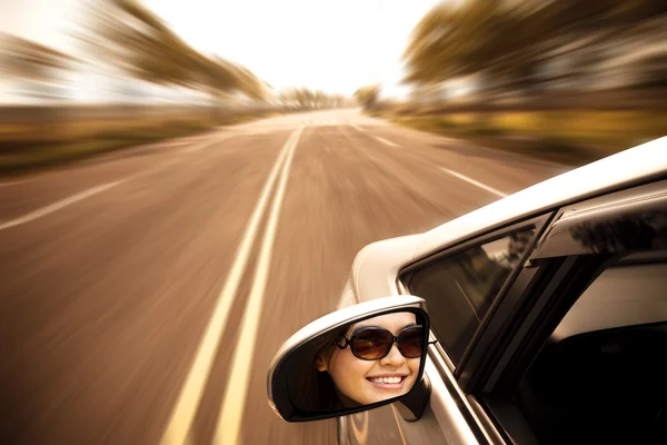 Młoda kobieta jazdy samochodu na drodze — Zdjęcie stockowe