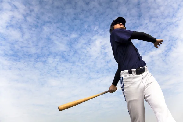 Baseballspieler nimmt Schaukel mit Wolkenhintergrund — Stockfoto