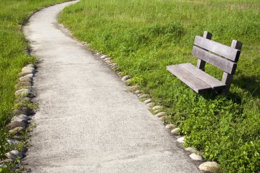 Curved road with chair in the park clipart