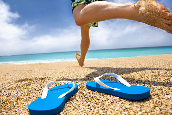 Man running on the beach and slipper