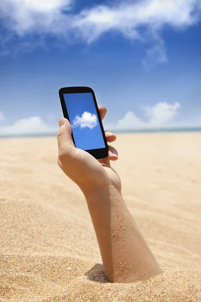 Telefone inteligente na mão e vista de praia com conceito de computação em nuvem — Fotografia de Stock