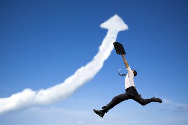 Jumping businessman with business growing graph cloud