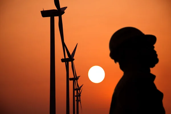 La sagoma dei mulini a vento lavoratore con tramonto — Foto Stock