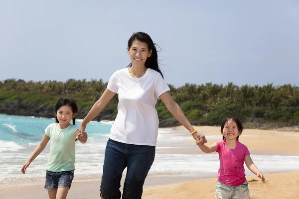Азиатская мать с детьми, гуляющая по пляжу — стоковое фото