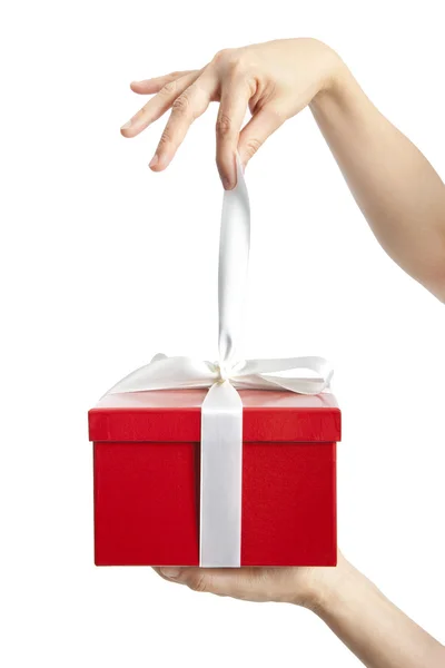 Hand holding ribbon and open gift box — Stock Photo, Image