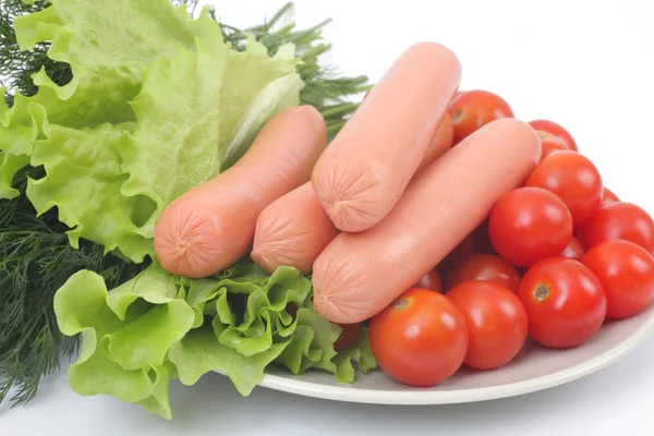 Fresh sausages on a plate with vegetables. — Stock Photo, Image
