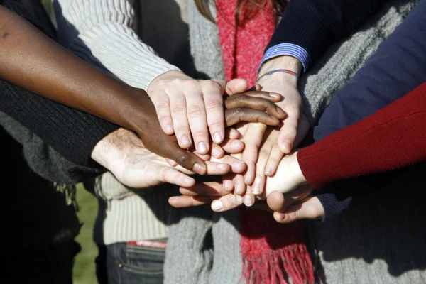 Grupo joven con las manos apiladas juntas — Foto de Stock