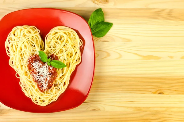 Λατρεύω τα ζυμαρικά / μακαρόνια σε ένα πιάτο και ξύλινο τραπέζι / Sh καρδιά — Φωτογραφία Αρχείου