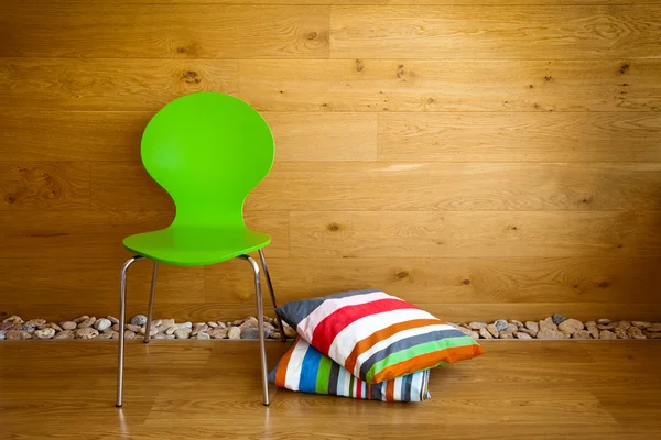 グリーンの椅子と木製の壁/モダンでカラフルな枕 — ストック写真