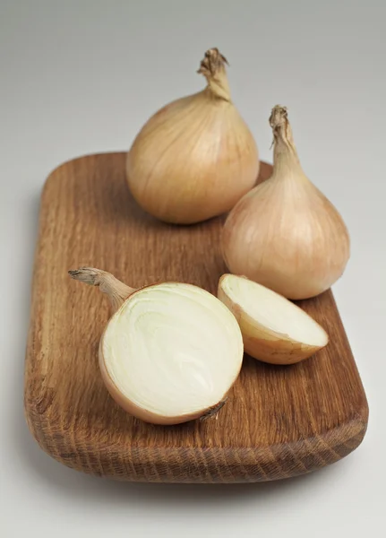 Onions on a wooden board. — Stock Photo, Image