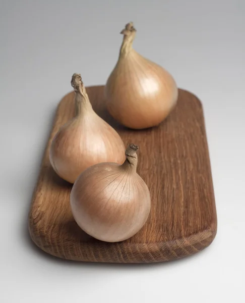 Onions on a kitchen board. — Stock Photo, Image