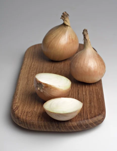 Onions on a kitchen board. — Stock Photo, Image