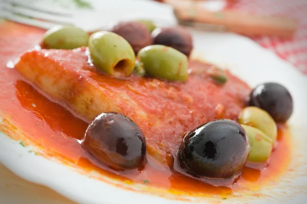 Vissen met olijven in tomatensaus. — Stockfoto