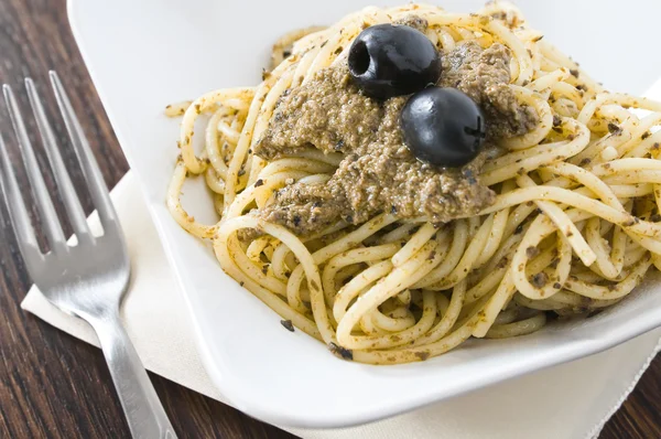 Spaghetti met zwarte olijven pesto. — Stockfoto