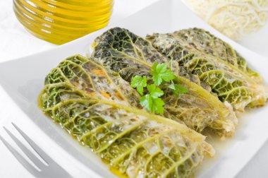 Savoy cabbage rolls on white dish. clipart