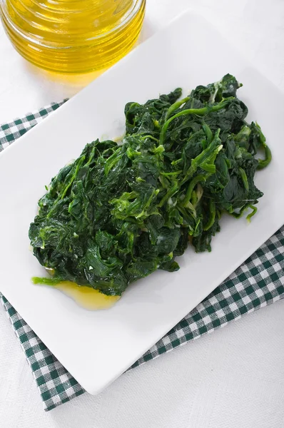Gekookte spinazie op witte schotel. — Stockfoto