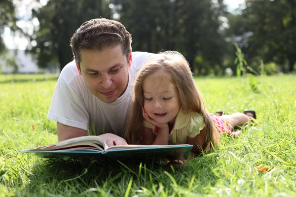 Fatherr와 함께 책을 읽는 어린 소녀 스톡 사진