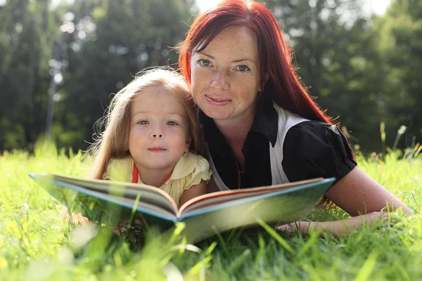 Мать и девочка читают книгу Лицензионные Стоковые Изображения