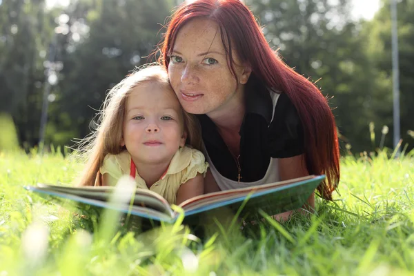Мати і дитина читають книгу Ліцензійні Стокові Фото