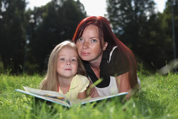 Madre y niña leyendo libro Imagen De Stock