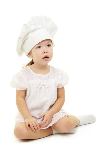 Baby flicka i cook hatten Stockbild