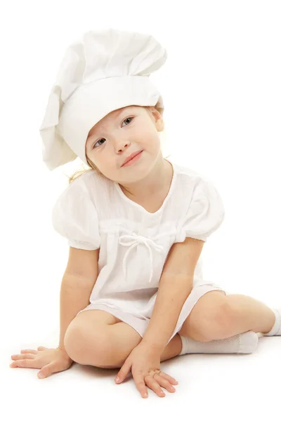 Baby flicka i cook hatten Stockfoto