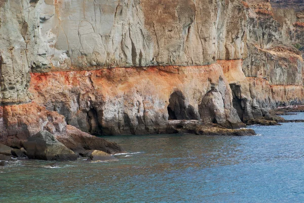 stock image Brown volcanic cliff in sea