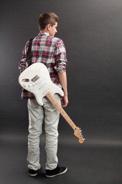 Teenager standing with electric guitar clipart