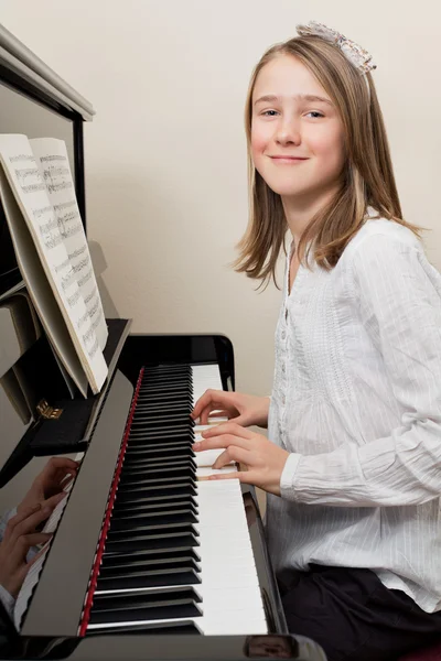 Szczęśliwa młoda dziewczyna gra na pianinie — Zdjęcie stockowe