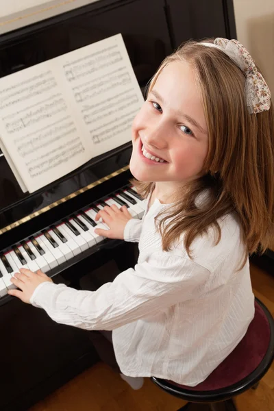 Mosolygó lány játszik a zongora — Stock Fotó