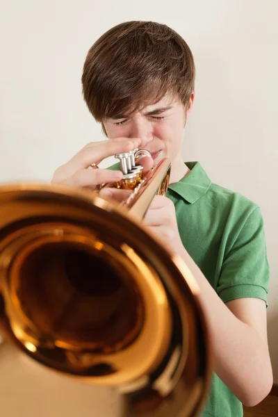 Подросток играет на золотой трубе — стоковое фото