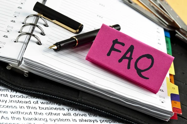 FAQ note on agenda and pen — Stock Photo, Image