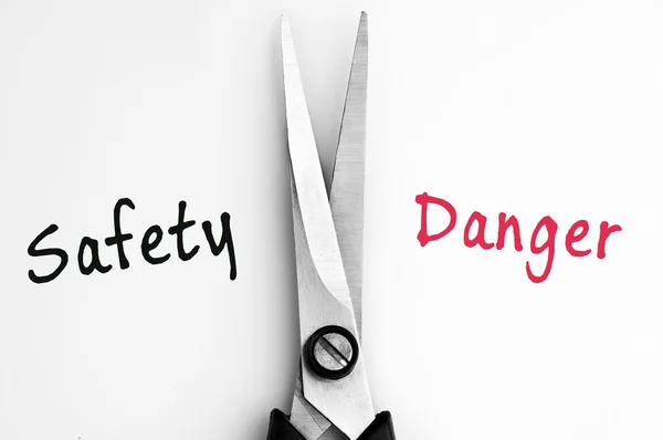 Palavras de segurança e perigo com tesoura no meio — Fotografia de Stock