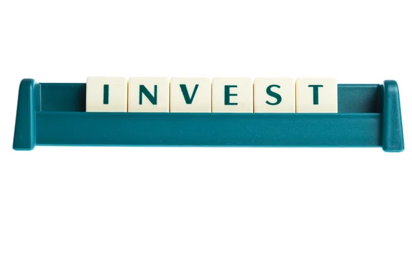 Invest word on isolated letters board — Stock Photo, Image