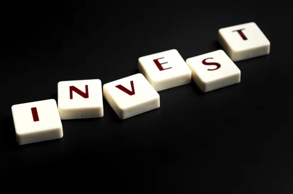 Invest word made by letter pieces — Stock Photo, Image