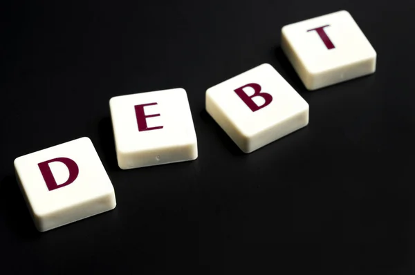 Schuldenwort aus Buchstabenstücken — Stockfoto