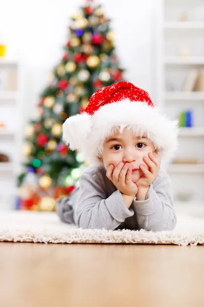 Χαριτωμένο αγόρι μπροστά από το χριστουγεννιάτικο δέντρο — Φωτογραφία Αρχείου