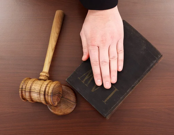 Hand on law book and gavel — Stock Photo, Image