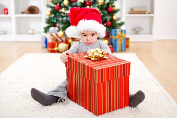 Malý chlapec sedí za velký dárek — Stock fotografie