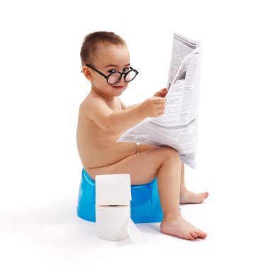Little boy sitting on potty and reading newspaper clipart