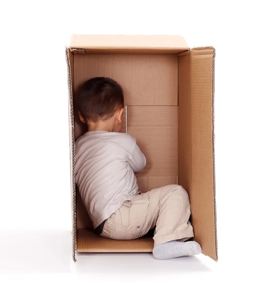 Little boy hiding in cardboard box — Stock Photo, Image