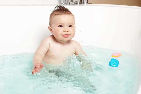 Lindo bebé que se divierte y sonríe mientras toma un baño —  Fotos de Stock