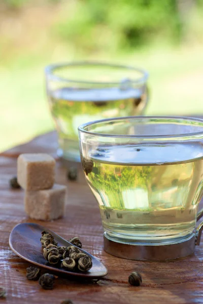 Green tea infuser with sugar cubes — Stock Photo, Image