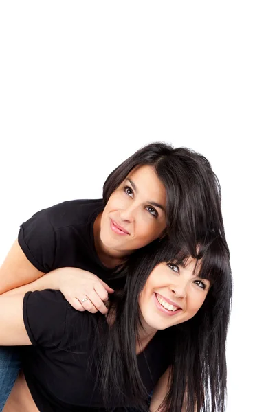 Two young women smiling and piggyback Stock Photo